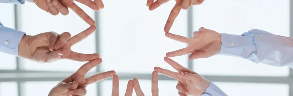 Menschen halten ihre Finger im Kreis aneinander um Motivation zu symbolisieren.