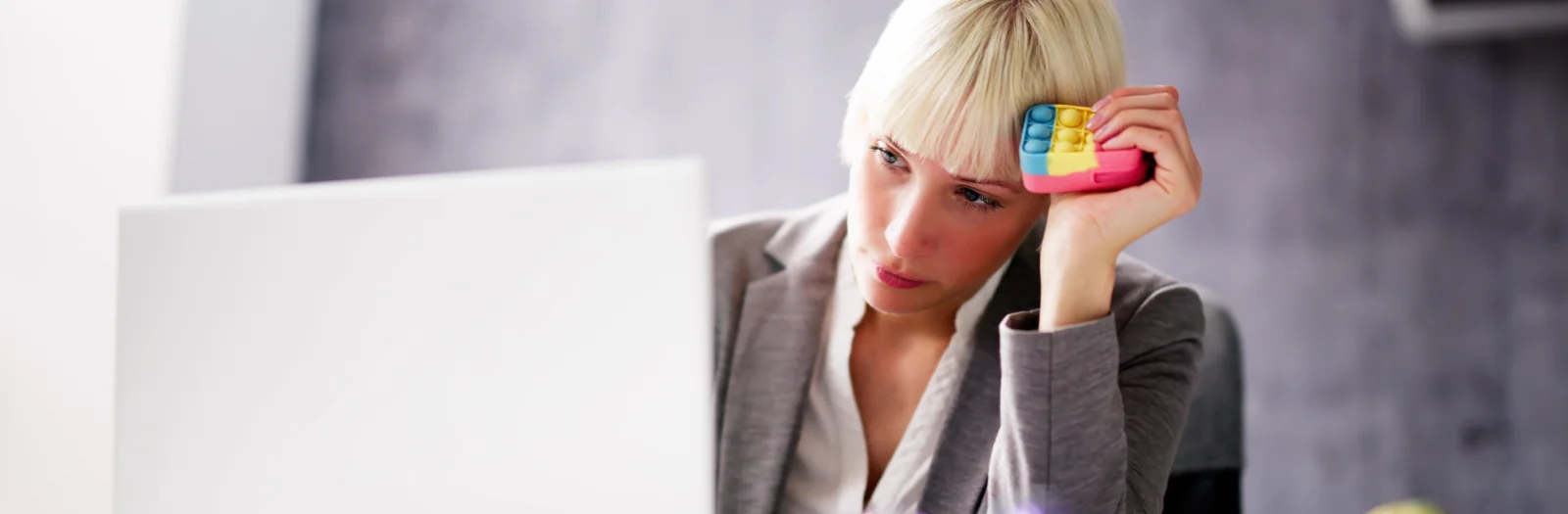 Frau im Büro hat Stress und versucht sich mit einem Stressspiel zu beruhigen